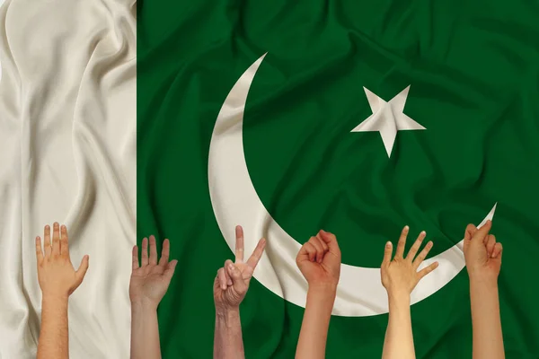 De nombreuses mains levées sur le fond du drapeau national du Pakistan sur la soie brillante délicate, concept de la population du pays, unité, horizontal, gros plan, espace de copie — Photo