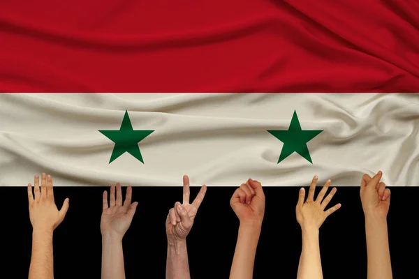 Багато рук підняли на тлі державного прапора Сирії на ніжний блискучий шовк, концепція населення країни, єдність, горизонтальне, Крупний план, копіювальний простір — стокове фото