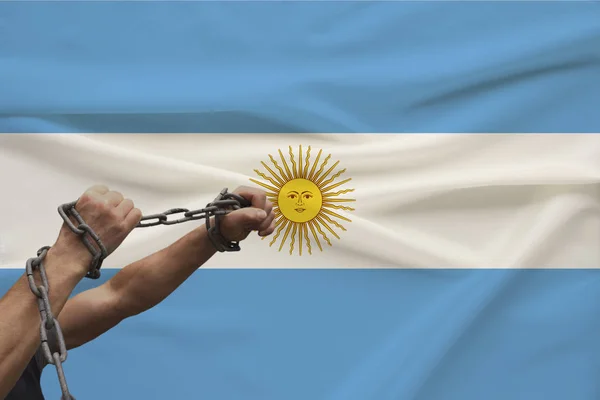 Manos masculinas musculosas envueltas en un grueso zar de hierro contra el fondo de la bandera del estado, el concepto de lucha política, crimen, crueldad, encarcelamiento, violación de la libertad humana — Foto de Stock