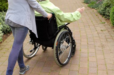 engelli bir kişinin parkında yaşlı bir kadın sürüş kadın, arka görüş, ufuk dinamik bir resim vermek için kaymıştır
