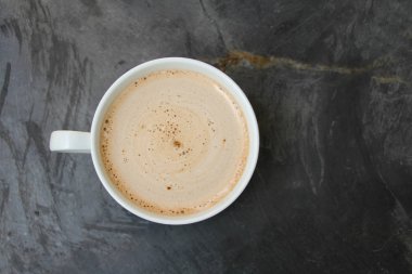 bir taş siyah çizgili masa üzerinde kapuçino ve tatlılar ile beyaz fincan, üst görünümü, yakın çekim, kopya alanı