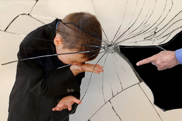 kırık bir ayna kırıkları yansıması, ağlayan bir çocuk, bir ortaokul çocuğu, köşede duruyor, duvara bakan, bir yetişkin el bir parmak ile gösterilir