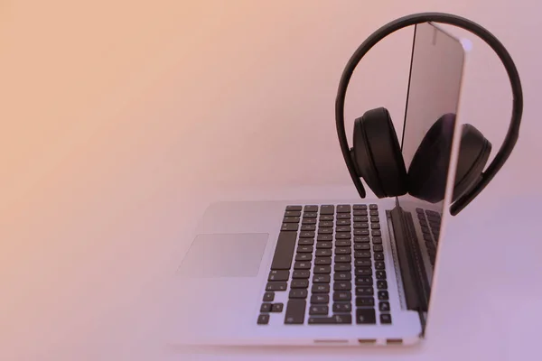 Tinted image of headphones on a black laptop keyboard — Stock Photo, Image