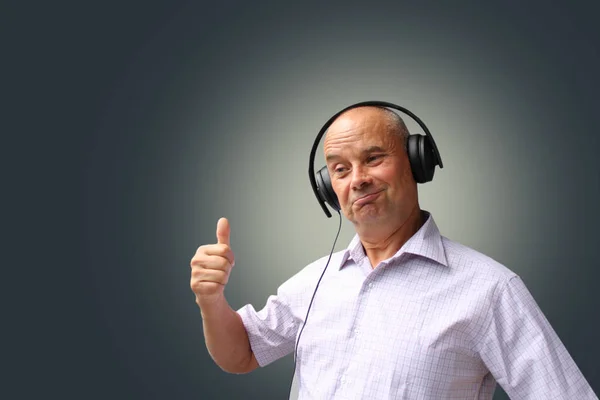 Oudere man in zwarte koptelefoon met emoties op zijn gezicht gebaren, isoleren, fotograferen, concept, close-up, kopieer ruimte — Stockfoto