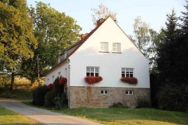 Old medieval european half-timbered house among green trees — Stock Photo, Image