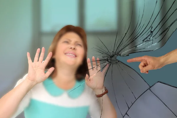 Imagem turva de uma mulher de meia-idade segurando as duas mãos na frente do rosto, em frente a uma mão masculina mostrando o dedo para ela, rachaduras, o conceito de fracasso, resistência, protesto, violência, gaslighting — Fotografia de Stock