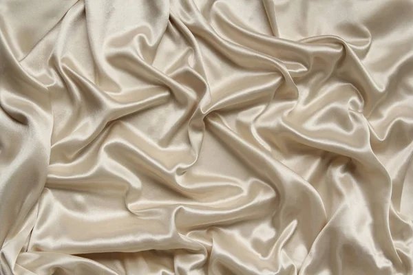 Crudo, crema hermoso satén cubierto con pliegues suaves, fondo de tela de seda, primer plano, espacio de copia — Foto de Stock