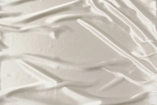 Tela de satén hermosa blanca cubierta con pliegues suaves, fondo de tela de seda, primer plano, espacio de copia — Foto de Stock