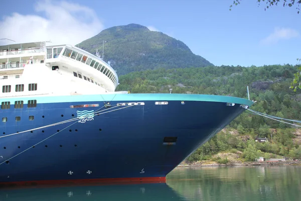 Hillesult, Noorwegen-juli 2019: multi-tiered Blue cruiseschip van het Spaanse bedrijf Pullmantur Cruises staat aan de pier in de prachtige Scandinavische fjord van Noorwegen tussen de hoge bergen, dichtbij- Rechtenvrije Stockfoto's