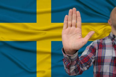 protesto bir jest ile erkek el, bir ipek ulusal bayrak fonunda yeminler, inkar ve yasaklama ve yasaklama kavramı, yakın çekim, kopyalama alanı