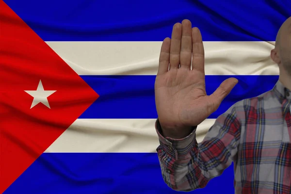 Mężczyzna ręka z gestem protestu, przysięgi na tle flagi narodowej jedwabiu, pojęcie odmowy i zakaz i zakaz, zbliżenie, przestrzeń kopiowania — Zdjęcie stockowe