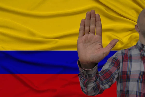 Αρσενικό χέρι με μια χειρονομία διαμαρτυρίας, όρκους με φόντο μια σημαία του μεταξιού, η έννοια της άρνησης και της απαγόρευσης και της απαγόρευσης, κοντινό, αντίγραφο χώρου — Φωτογραφία Αρχείου