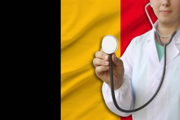 Fotografía parcial de una doctora, enfermera con un estetoscopio en uniforme en el fondo de la bandera nacional del estado de Alemania, el concepto de atención médica y seguro en el país — Foto de Stock