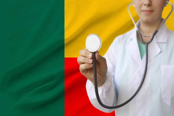 partial photograph of a doctor���s girl, a nurse with a stethoscope in uniform against the background of the colored national flag of the United Kingdom, a concept of medical care and insurance in the
