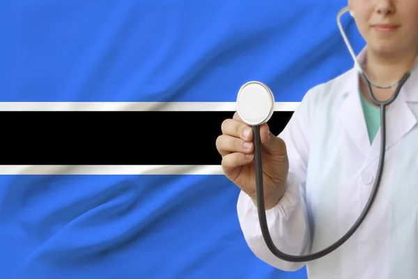 partial photograph of a doctor���s girl, a nurse with a stethoscope in uniform against the background of the colored national flag of the United Kingdom, a concept of medical care and insurance in the