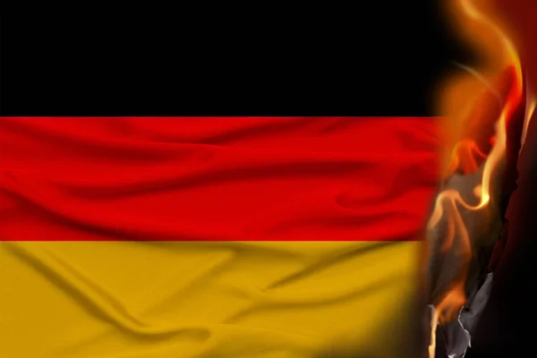 Orange flames and ashes on the burning national flag of the state of Germany, the concept of revolution, war, coup, destruction, fires in the country, close-up — Stock Photo, Image