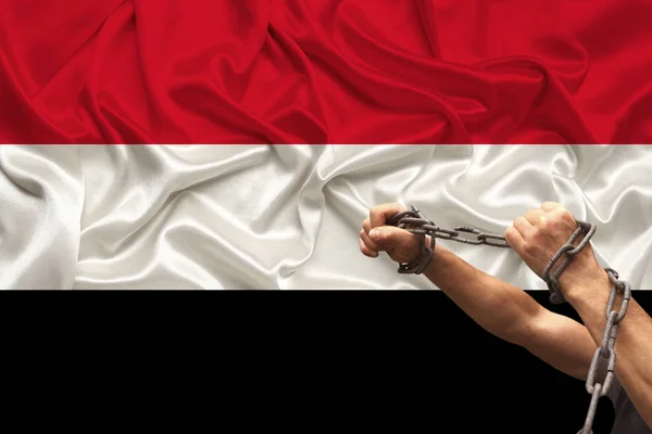 Mani maschili incatenate in catene di ferro sullo sfondo della bandiera nazionale di seta degli yemen, concetto di protesta, divieto di crimine, primo piano, spazio copia — Foto Stock