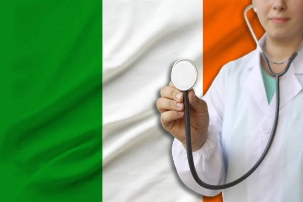 partial photograph of a doctor���s girl, a nurse with a stethoscope in uniform against the background of the colored national flag of the United Kingdom, a concept of medical care and insurance in the