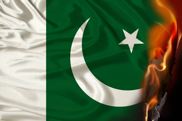 Orangefarbene Flammen und Asche auf der stolzen Nationalflagge des pakistanischen Staates, das Konzept von Revolution, Krieg, Staatsstreich, Zerstörung, Bränden im Land, Nahaufnahme — Stockfoto