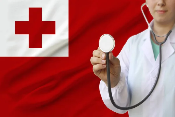 partial photograph of a doctor���s girl, a nurse with a stethoscope in uniform against the background of the colored national flag of the United Kingdom, a concept of medical care and insurance in the