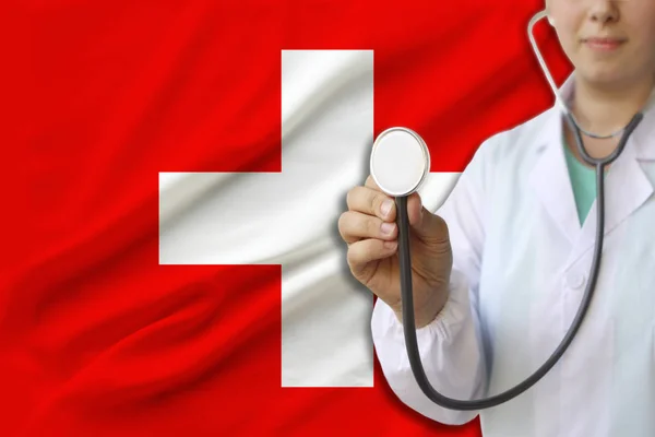 partial photograph of a doctor���s girl, a nurse with a stethoscope in uniform against the background of the colored national flag of the United Kingdom, a concept of medical care and insurance in the