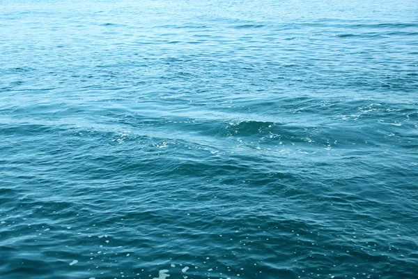 Blaues Meer, Meereswellen, Wasser mit Schaum und Blasen, Textur, Konzept der natürlichen Wasserressourcen, Nahaufnahme, Kopierraum — Stockfoto