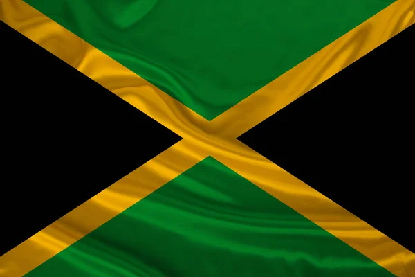 Foto van de nationale vlag van de staat Jamaica op een luxueuze textuur van satijn, zijde met golven, plooien en Highlights, close-up, kopieer ruimte, illustratie — Stockfoto