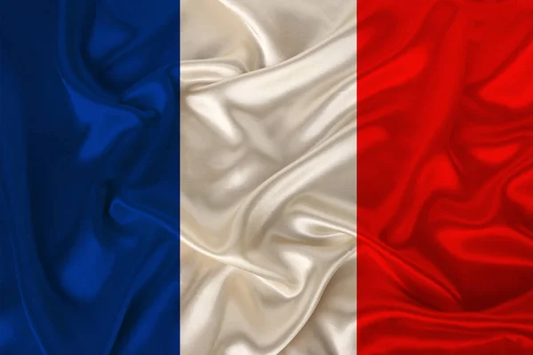 Photo of the national flag of France on a luxurious texture of satin, silk with waves, folds and highlights, closeup, copy space, concept of travel, economy and state policy, illustration — Stock Photo, Image