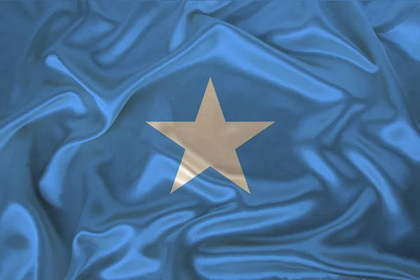 Foto van de nationale vlag van Somalië op een luxueuze textuur van satijn, zijde met golven, plooien en Highlights, close-up, kopieer ruimte, reis concept, economie en staatsbeleid, illustratie — Stockfoto