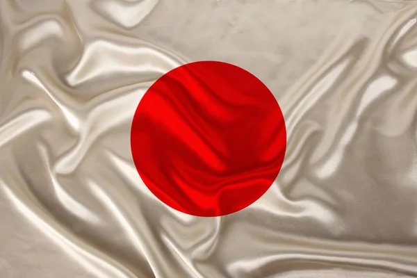 Foto da bandeira nacional do Japão em uma textura luxuosa de cetim, seda com ondas, dobras e destaques, close-up, espaço de cópia, conceito de viagem, economia e política de estado, ilustração — Fotografia de Stock
