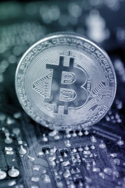 elektronik sikke, anakart koyu bir arka plan üzerinde gümüş sikke, kavram madenciliği, kopya alanı, yakın çekim, dikey