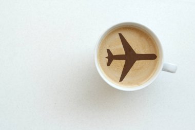beyaz geniş fincan kahve, sütlü kapuçino, beyaz masada uçak deseni olan kakao, üst tere, yer tasarrufu, seyahat konsepti, transfer