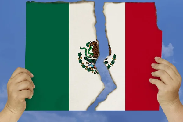 Woman holds in both hands against a blue sky torn in two cardboard with seared edges depicting the national flag of Mexico, the concept of a state crisis, renunciation of citizenship, destruction — Stock Photo, Image