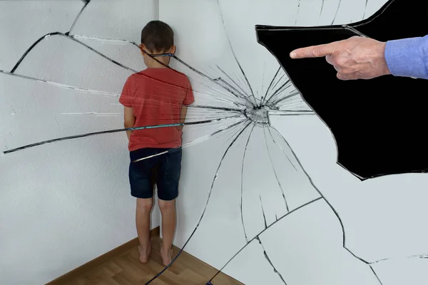 Reflejado en los fragmentos de un espejo roto. Un chico castigado, un estudiante de secundaria, está de pie en la esquina, girando hacia la pared. Las manos de los padres se muestran con un dedo, el concepto de humillación — Foto de Stock