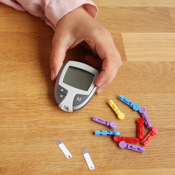 Glucomero medico per la misurazione di zucchero nel sangue umano e aghi colorati, su un tavolo di legno, concetto di controllo medico, diabete, vista dall'alto, primo piano, spazio di copia — Foto Stock
