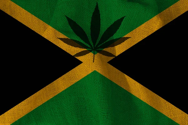 Зеленый лист конопли и красивый национальный флаг Ямайки, концепция медицинского конопли, легализация наркотиков, торговля наркотиками, крупный план — стоковое фото
