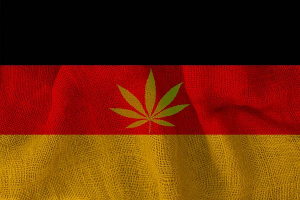 Grünes Hanfblatt und die schöne Nationalflagge Deutschlands, das Konzept von medizinischem Cannabis, die Legalisierung von Drogen, Drogendelikte, Nahaufnahme — Stockfoto