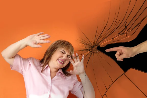 Mannelijke hand tegen een achtergrond van gebroken glas toont een beschuldigt gebaar bij een vrouw die haar handen in wanhoop gooide, psychologisch concept, gaslighting, geweld — Stockfoto