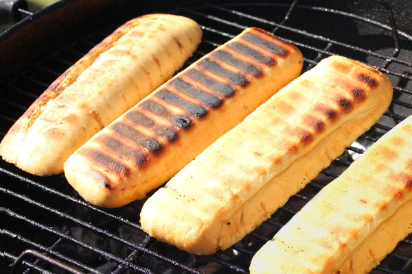 Appetitlich gegrilltes Brot wird auf der Straße auf einem schwarzen Metallgrill auf brennender Holzkohle gebraten, Picknickkonzept, Nahaufnahme — Stockfoto