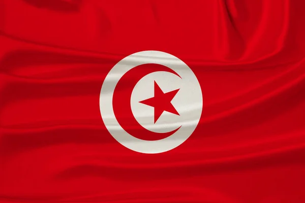 Beautiful photo of the national flag of Tunisia on delicate shiny silk with soft draperies, the concept of state power, country life, horizontal, close-up, copy space — Stock Photo, Image