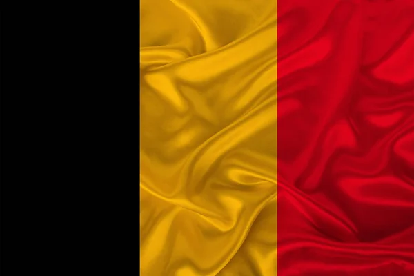 Photo of the national flag of Belgium on a luxurious texture of satin, silk with waves, folds and highlights, close-up, copy space, travel concept, economy and state policy, illustration — Stock Photo, Image