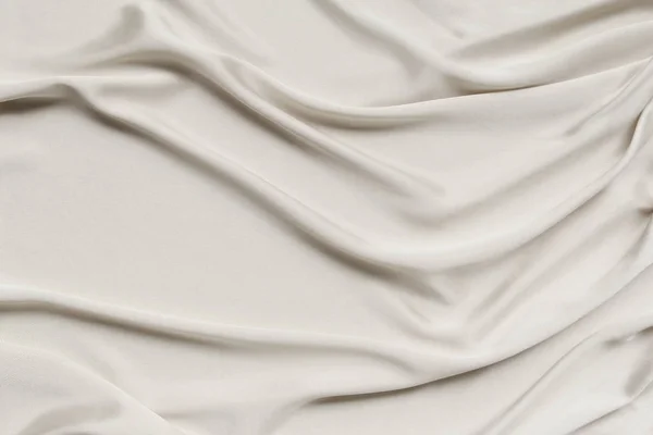Crudo, crema hermoso satén cubierto con pliegues suaves, fondo de tela de seda, primer plano, espacio de copia — Foto de Stock