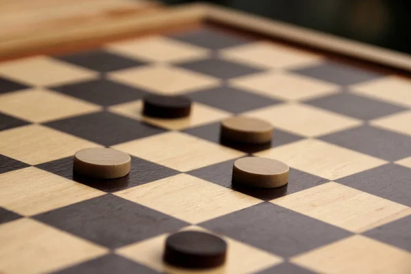 Pedine di legno bianco e marrone scuro su una scacchiera, concetto di gioco — Foto Stock
