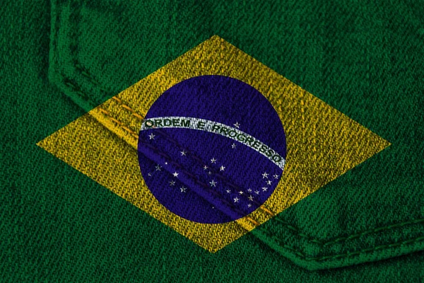 Foto da bandeira nacional do Brasil em uma textura luxuosa de cetim, seda com ondas, dobras e destaques, close-up, espaço de cópia, conceito de viagem, economia e política de estado, textura de jeans — Fotografia de Stock