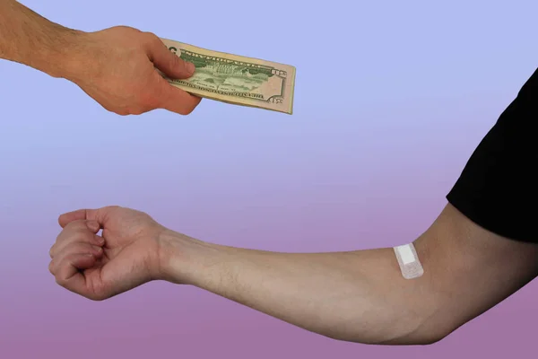 Mužská ruka s dolarovými bankovkami a rukou zapečetěnou na vnitřní straně lokte s lékařskou omítkou, koncept darování krve, detailní záběr — Stock fotografie
