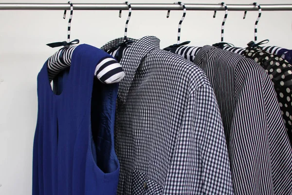 Set dameskleding van verschillende kleuren, effen en gestreept, op hangers, een concept voor mode en winkelen — Stockfoto