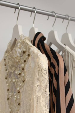 Beyaz ve renkli kadınlar askılarda giysi, moda ve alışveriş konsepti, dikey