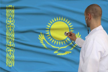 Profesyonel tıbbi üniformalı bir doktorun fotoğrafı Kazakistan devletinin ulusal bayrağının arka planında, sağlık konsepti, sınırları olmayan doktorlar, sigortası olmayan doktorlar