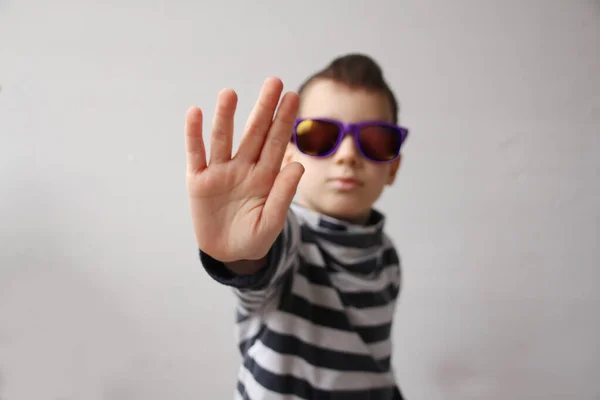 Junge mit dunkler Sonnenbrille und einem Mohawk auf dem Kopf schließt die Handfläche, Stopp-Geste, selektiver Fokus auf die Hand, Protestkonzept, Nahaufnahme, Konzept der psychischen und physischen Misshandlung, Demütigung — Stockfoto