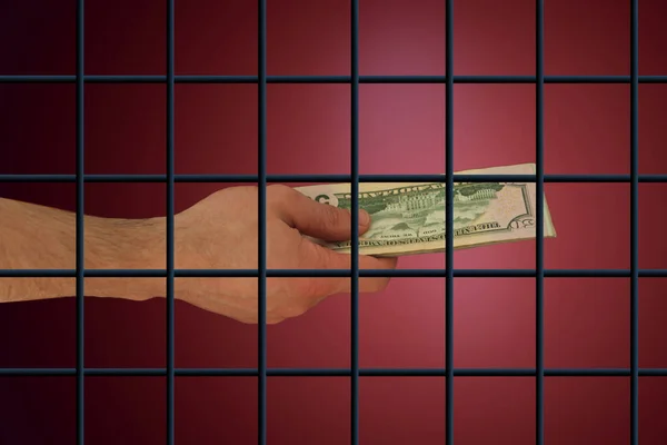 paper money American money, dollars in hand behind a black bars, illegal cash flow concept, close-up, copy space
